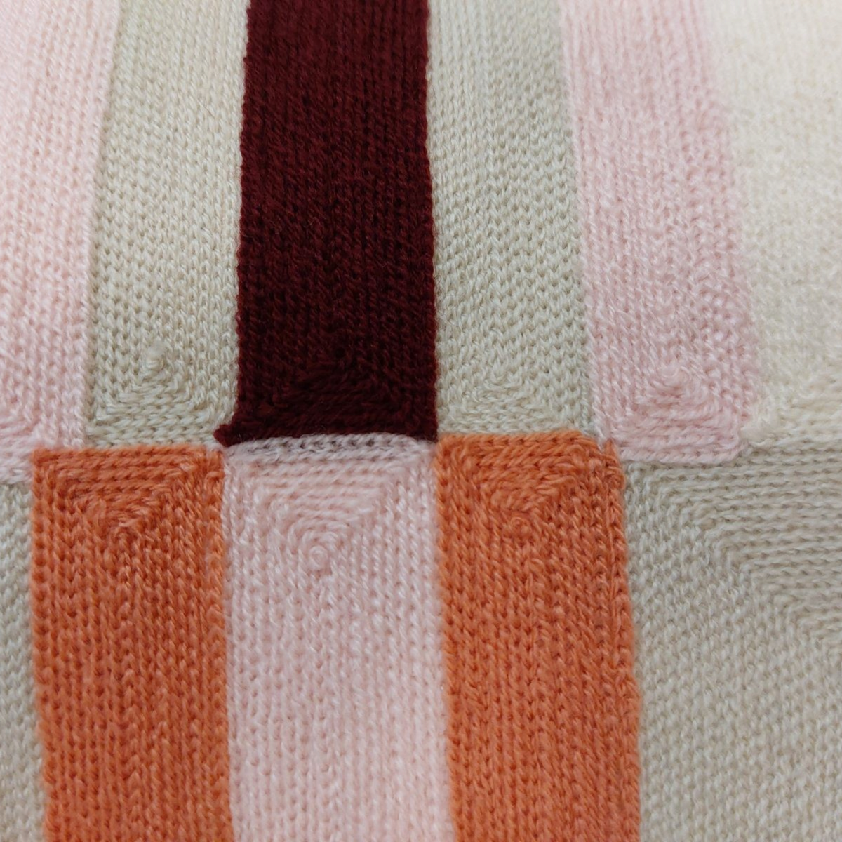 Gros plan sur la broderie texturée du coussin Depuis des lustres aux motifs géométriques colorés et élégants