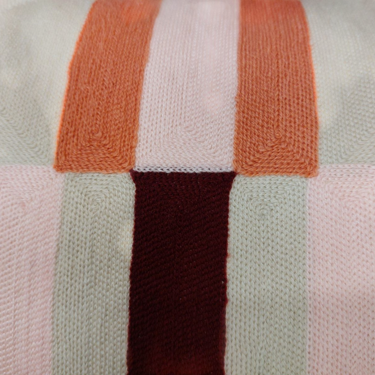 Gros plan sur la broderie géométrique du coussin Depuis des lustres Jason aux tons beige, bordeaux et corail.