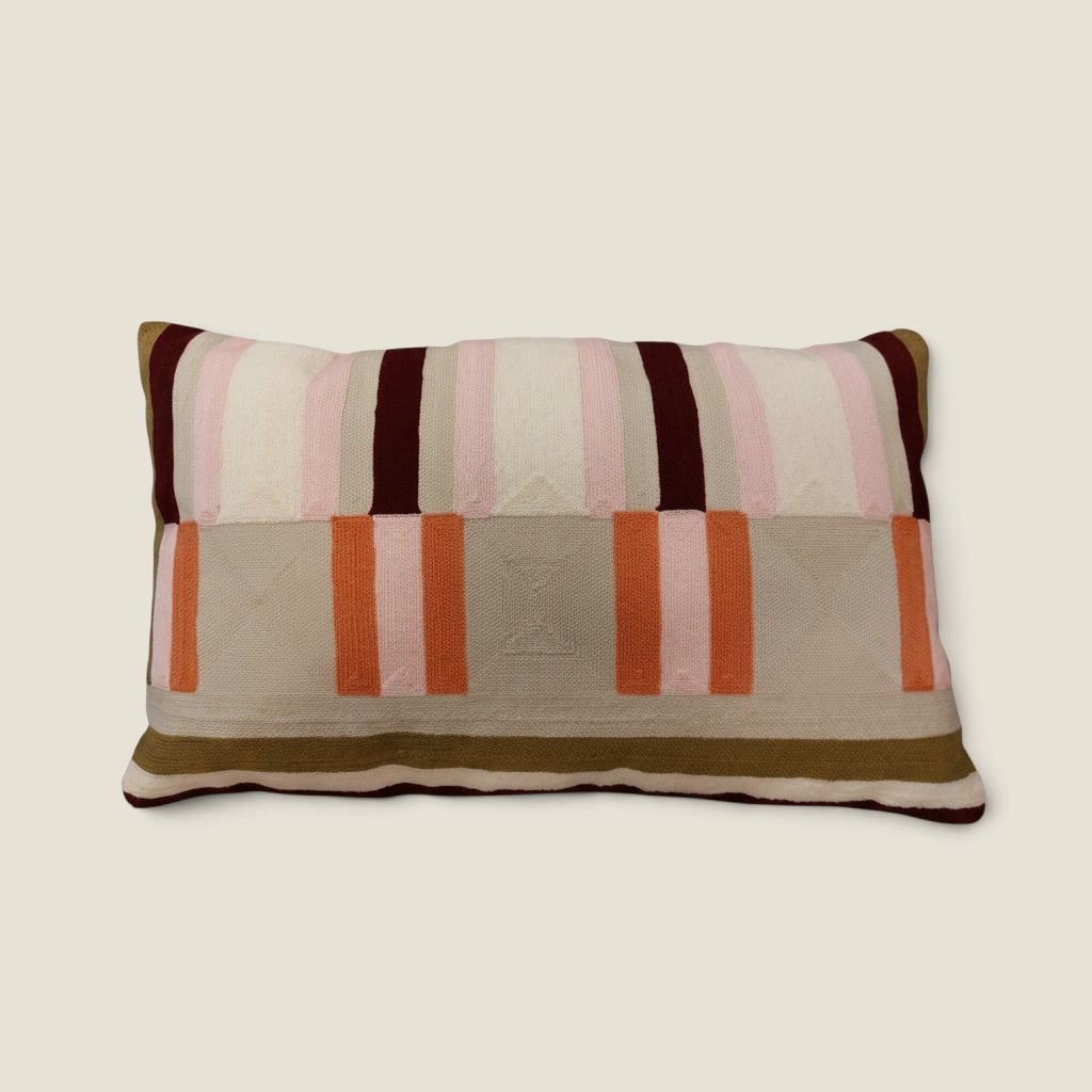 Coussin rectangulaire Depuis des lustres brodé avec des rayures géométriques dans des tons vert kaki, rose et orange.