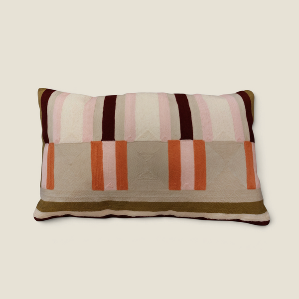 Coussin rectangulaire Depuis des lustres brodé avec des rayures géométriques dans des tons vert kaki, rose et orange.