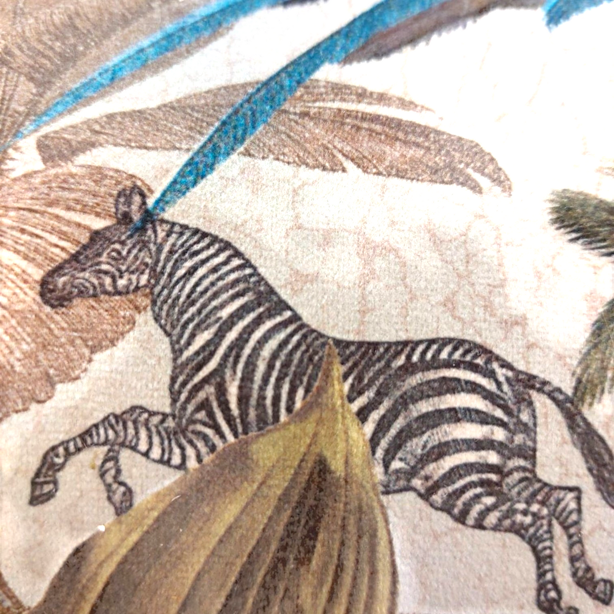 Depuis des lustres velvet cushion featuring a zebra in a botanical tropical scene with turquoise and beige accents