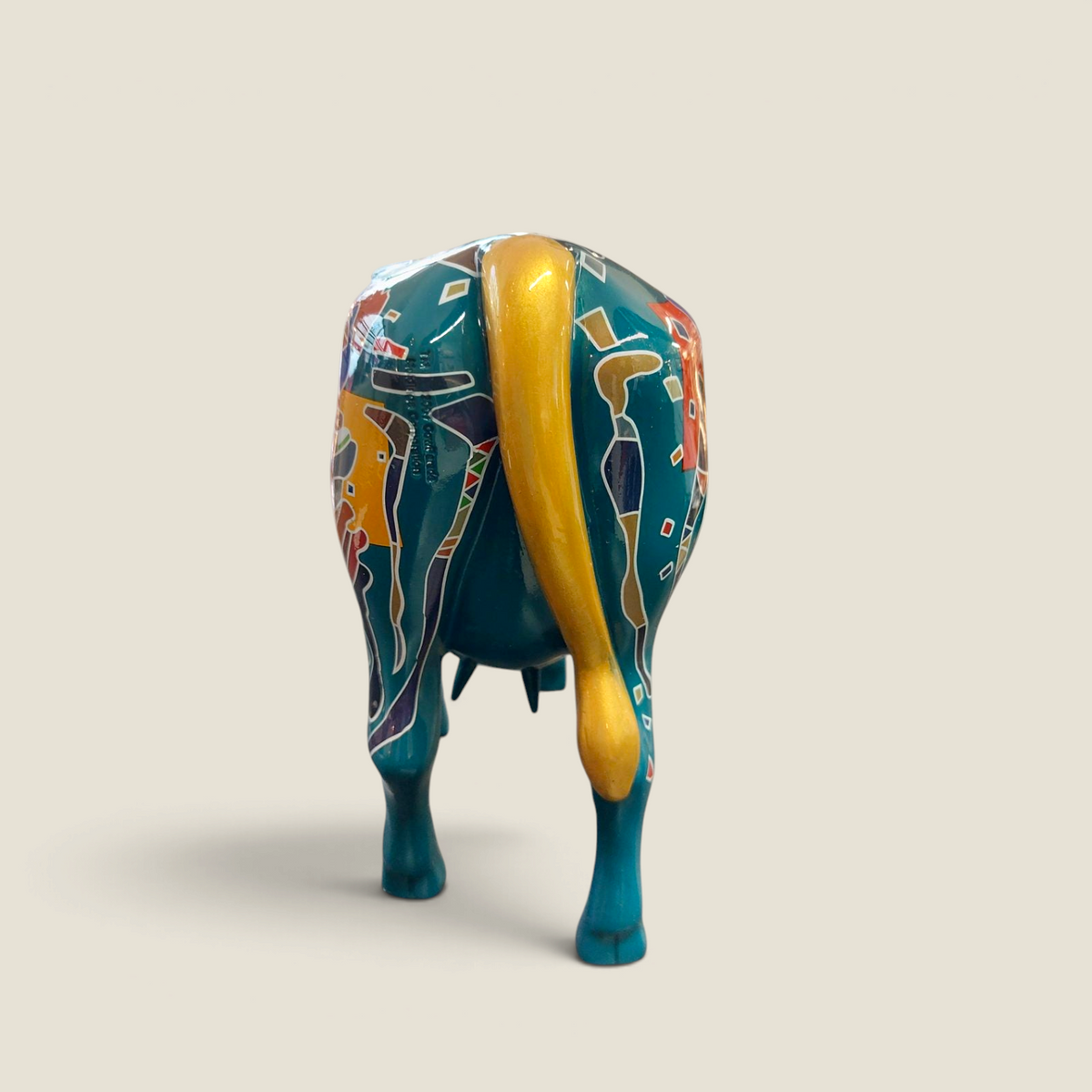 Vue arrière de la statuette de vache Depuis des lustres en résine turquoise avec motifs pop art et queue dorée