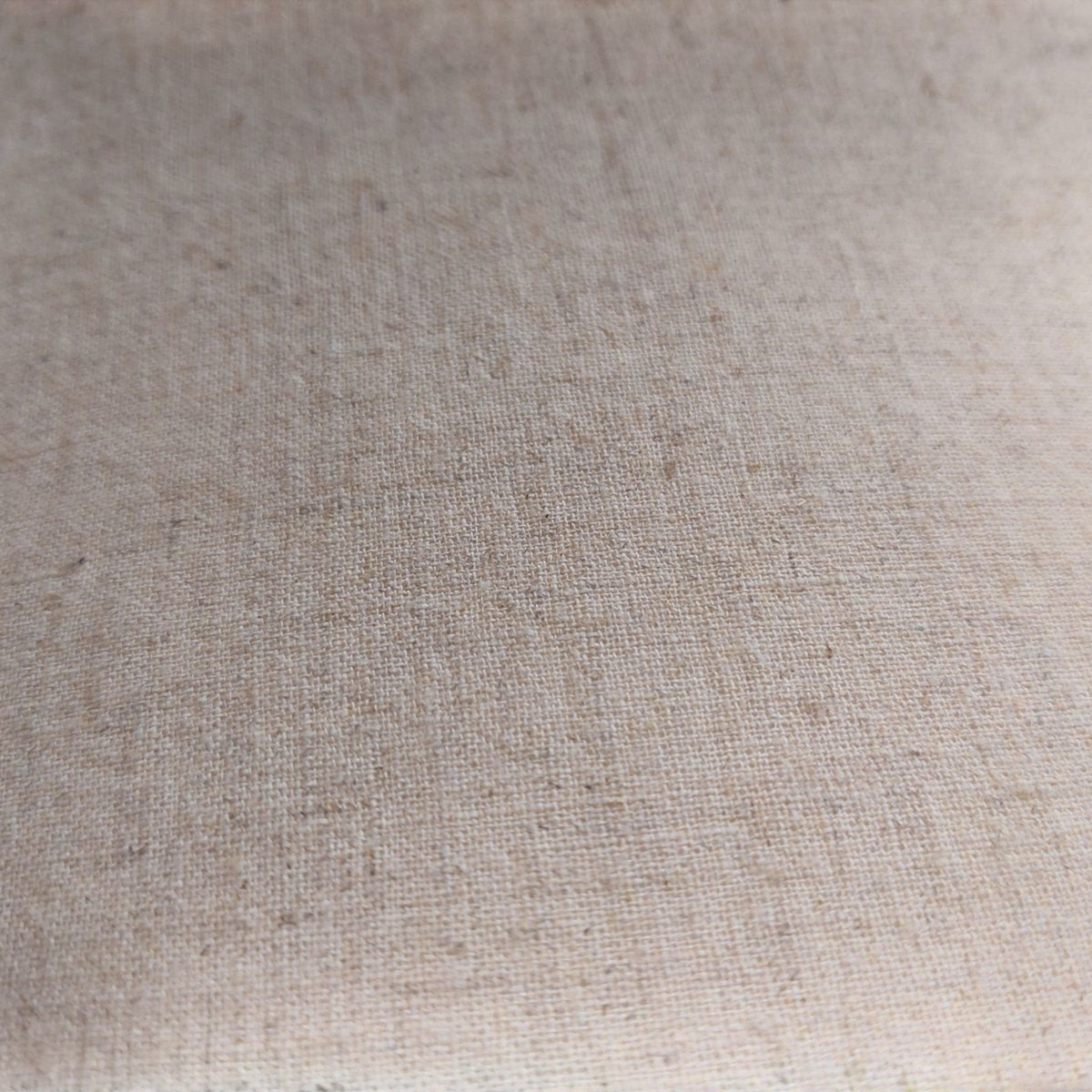 Gros plan sur le dos en lin beige écru du coussin décoratif TAHO par Depuis des lustres, texture naturelle et rustique