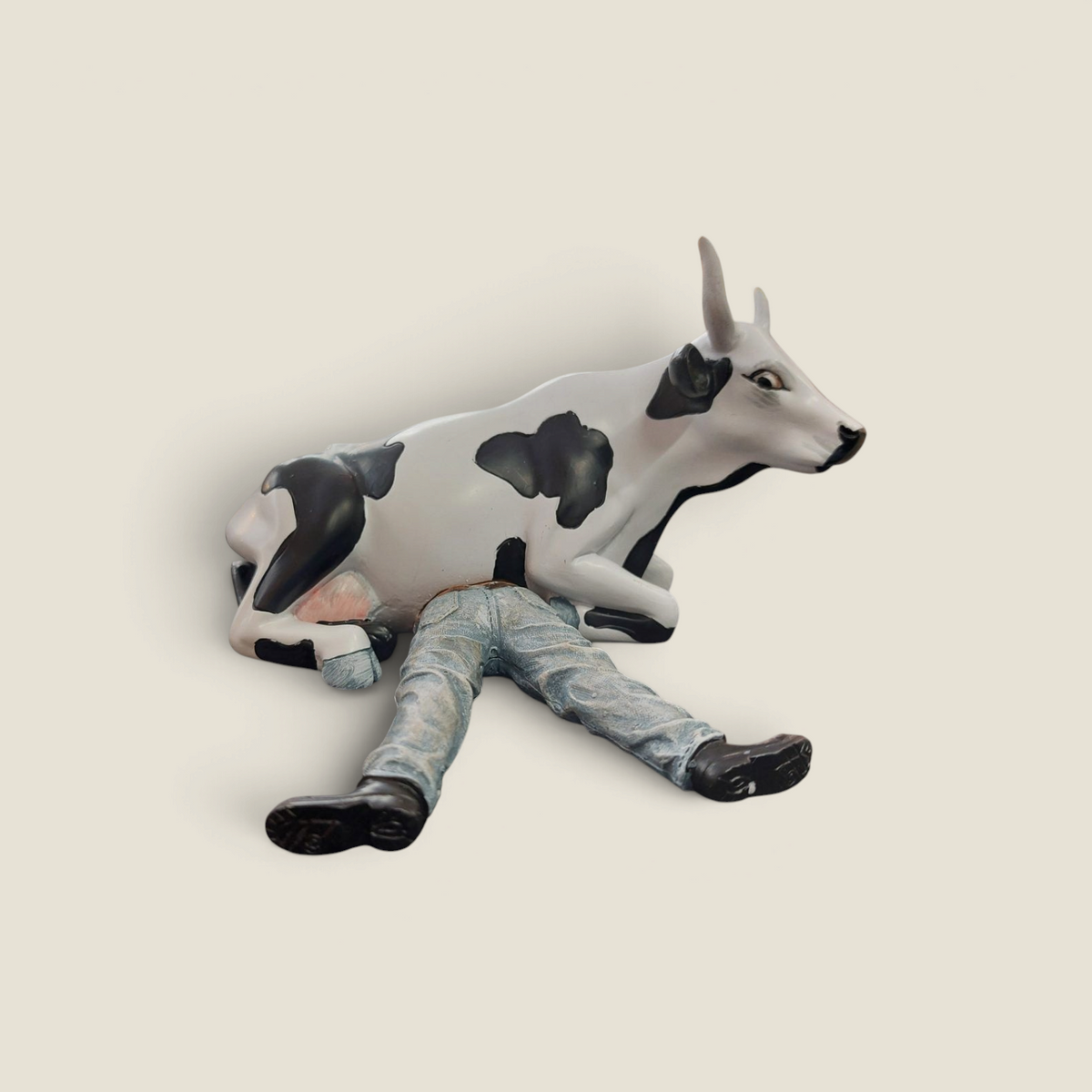 Figurine CowParade Depuis des lustres en résine représentant une vache Holstein assise sur un fermier en jean