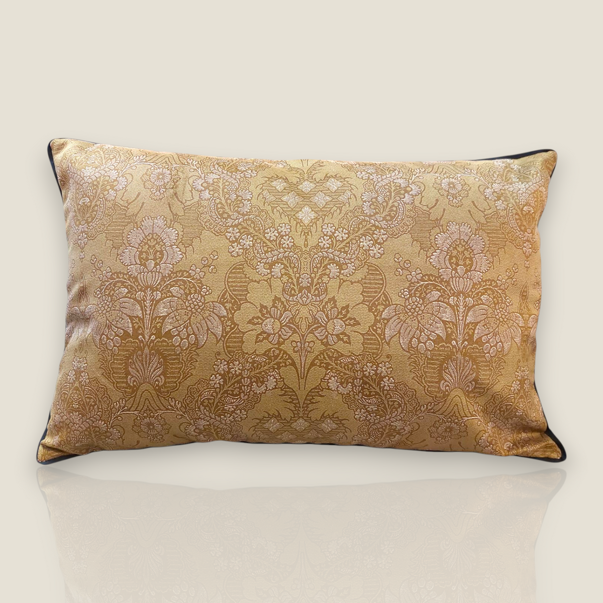 Depuis des lustres rectangular velvet cushion with intricate gold and beige botanical damask pattern and black piping.