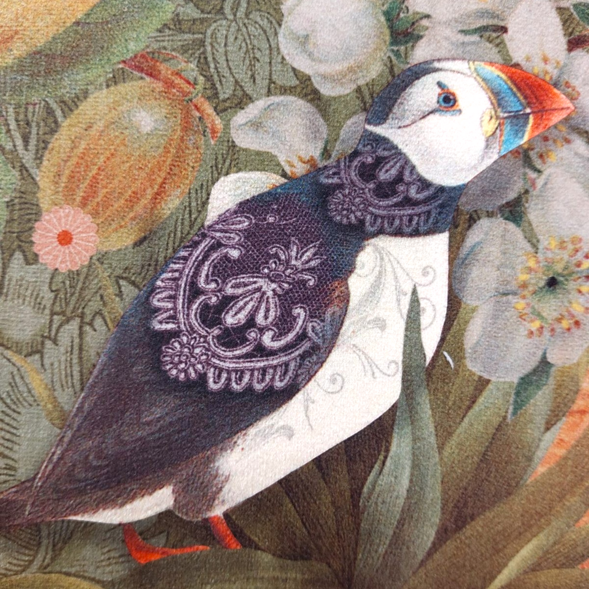Depuis des lustres velvet cushion featuring a detailed puffin illustration amidst olive green and gold floral patterns