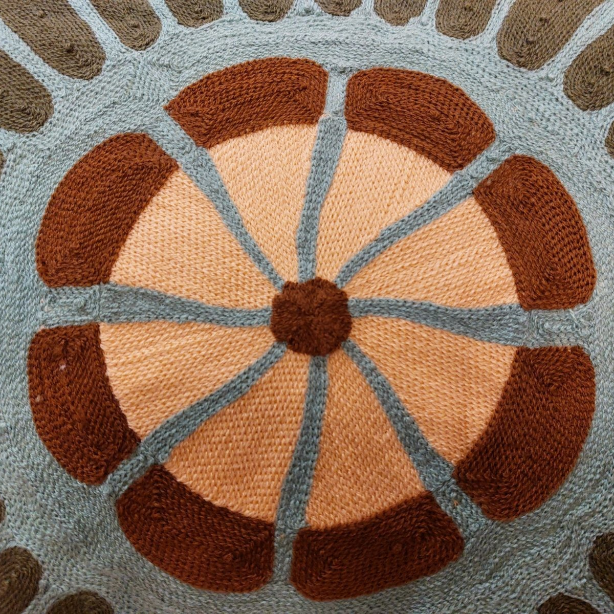 Gros plan sur la broderie artisanale du coussin Depuis des lustres Zeno Forêt avec motifs circulaires colorés