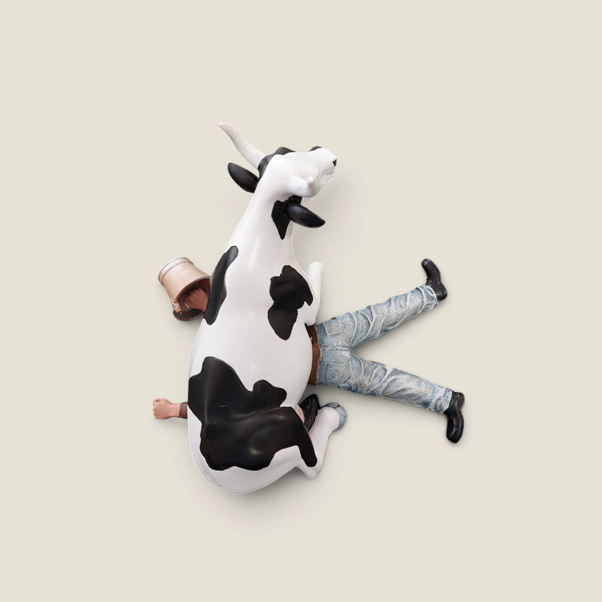 Figurine CowParade Depuis des lustres en résine représentant une vache Holstein assise sur un fermier en jean