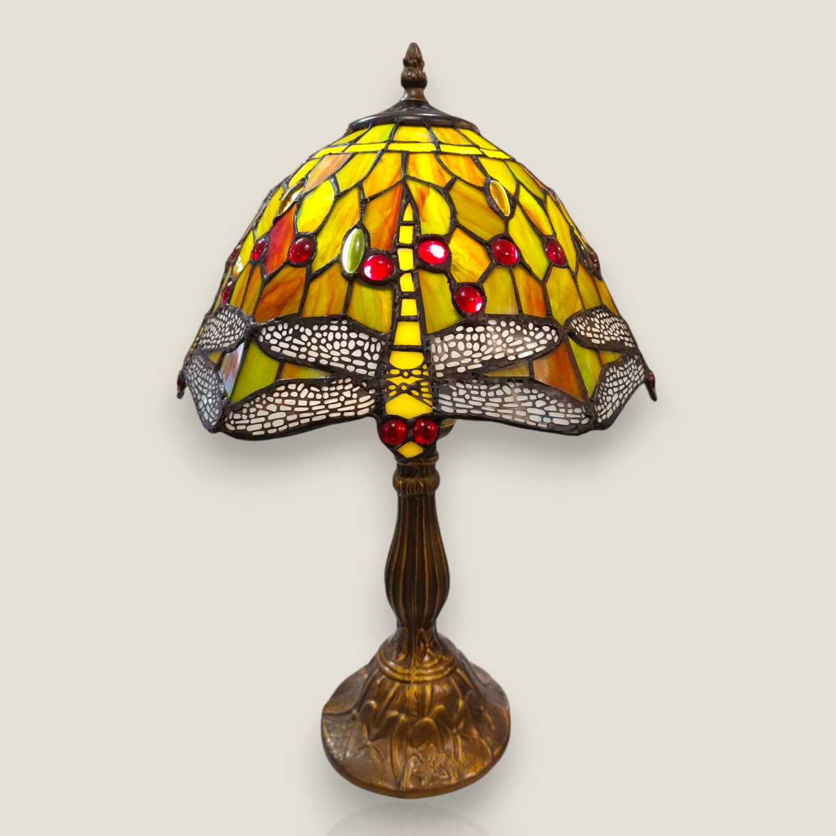 Depuis des lustres Tiffany style table lamp with dragonfly stained glass shade in green, yellow, orange, and red.