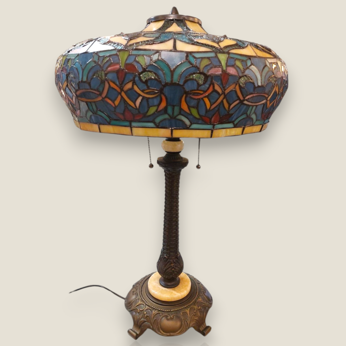 Depuis des lustres Tiffany style table lamp with a stained glass shade, bronze twisted base, and marble accents.