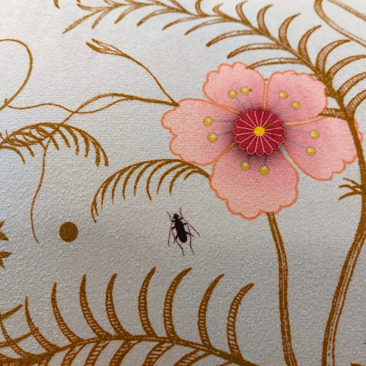Depuis des lustres velvet cushion featuring a botanical print with a pink flower, golden branches, and an insect.