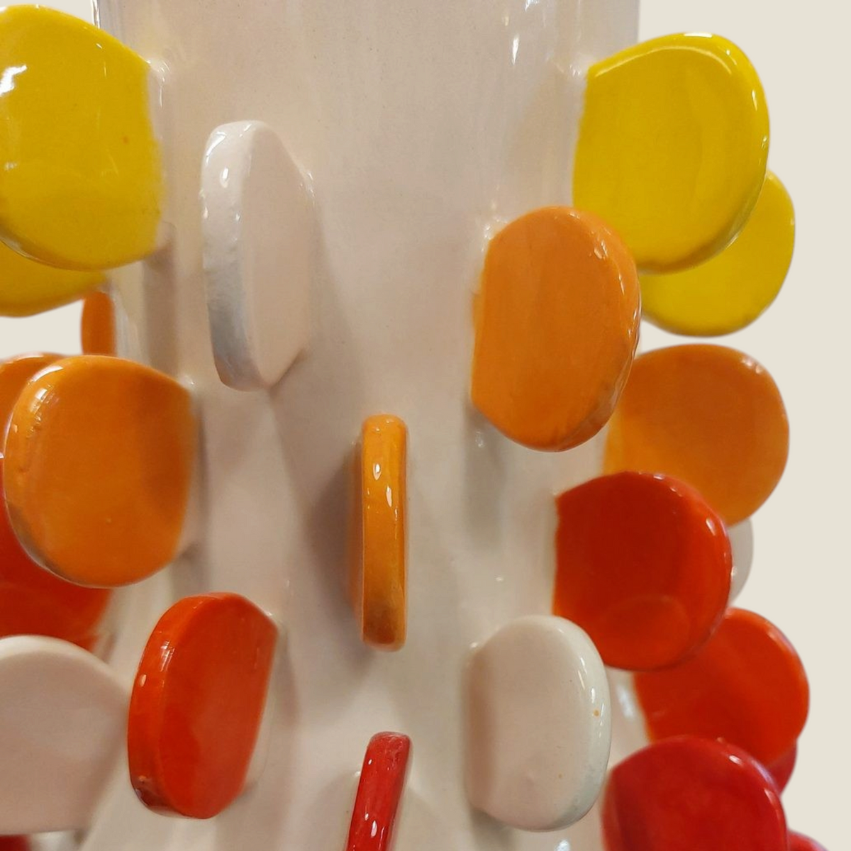 Vase en céramique Depuis des lustres avec pastilles en relief dégradées jaune, orange et rouge sur fond blanc brillant